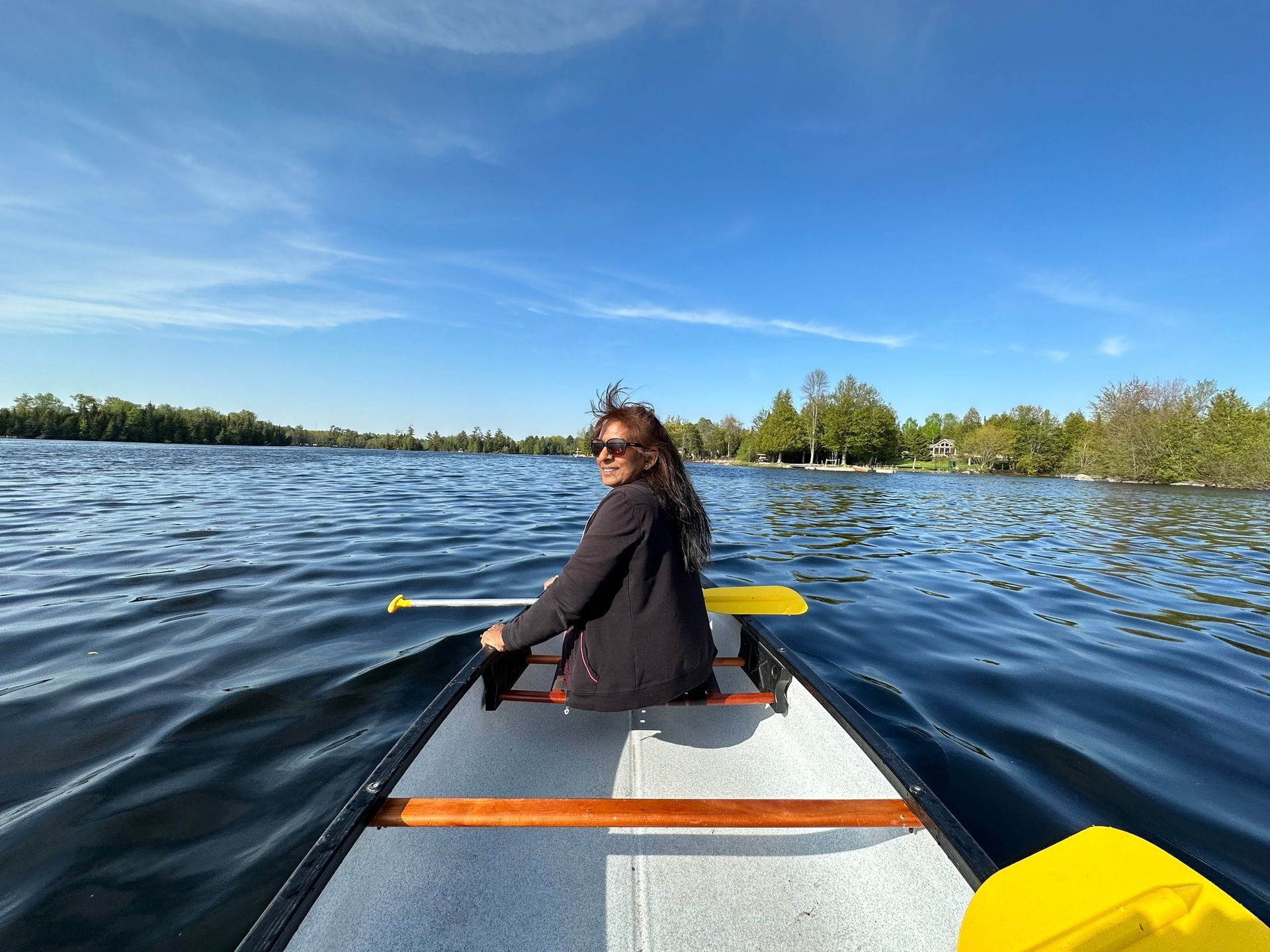 A woman is rowing a canoe on a lake.