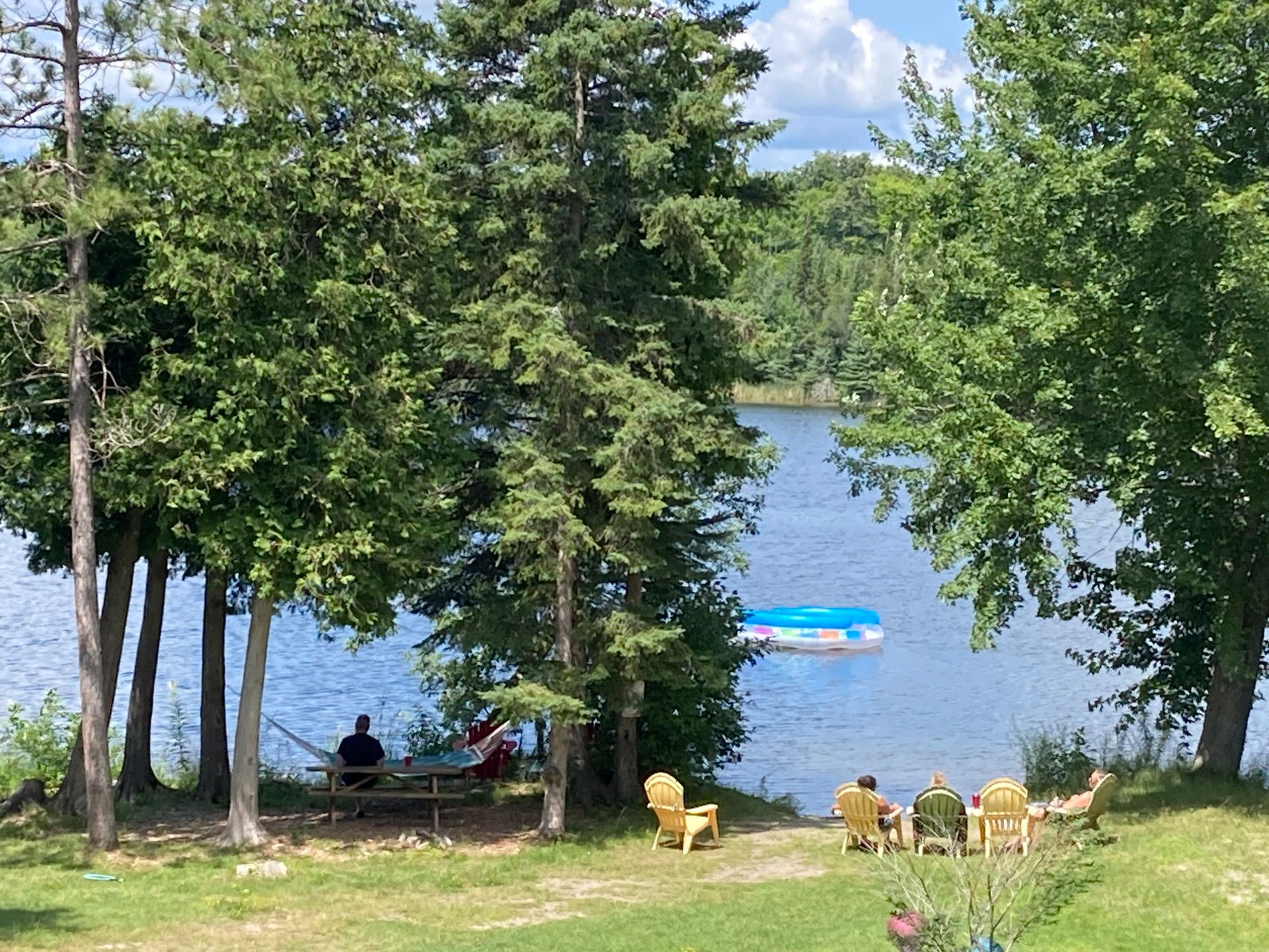 A group of people are sitting in chairs near a lake.