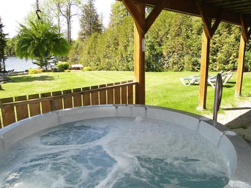 A hot tub with a view of a lake in the background