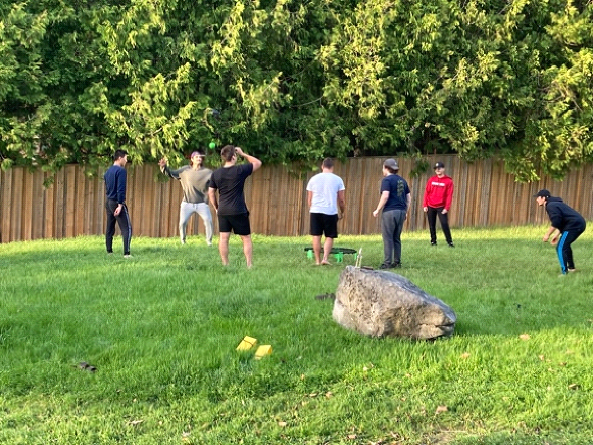 A group of people are playing a game of frisbee in a grassy field.