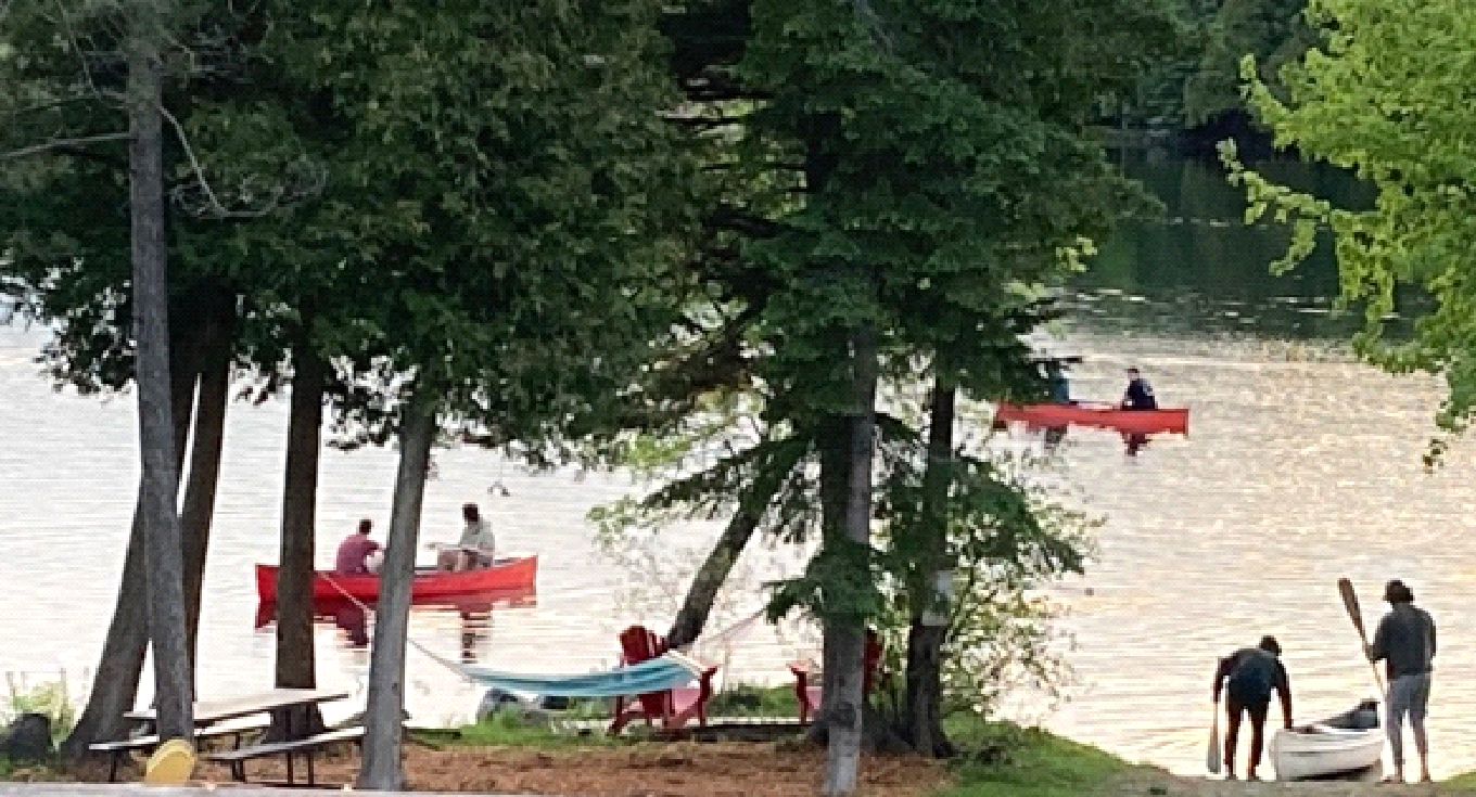 A group of people are rowing kayaks on a lake.