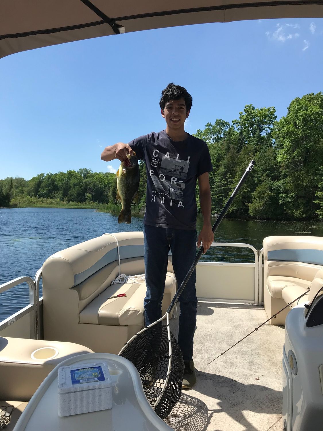 A man is standing on a boat holding a fish.
