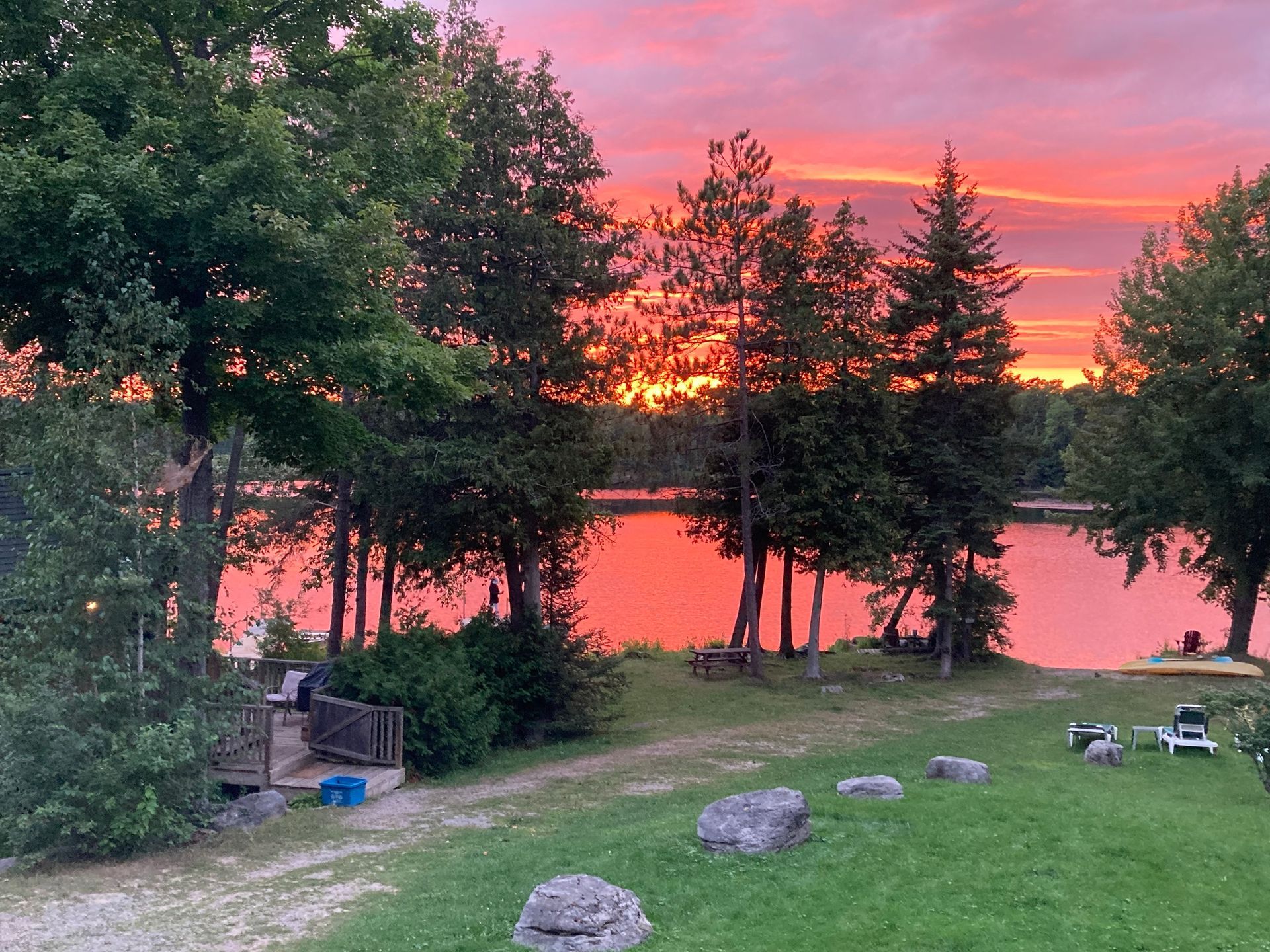 A sunset over a lake with trees in the foreground.