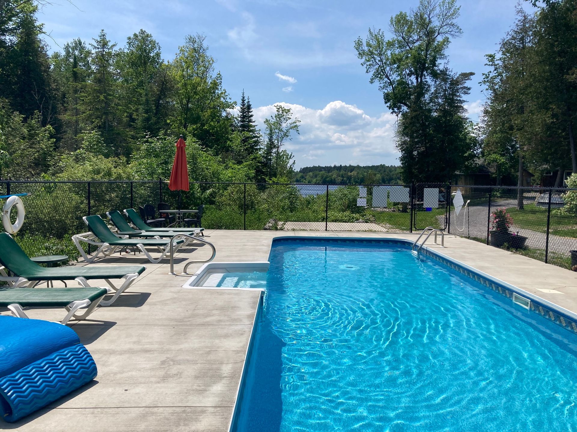 A large swimming pool with chairs and umbrellas around it