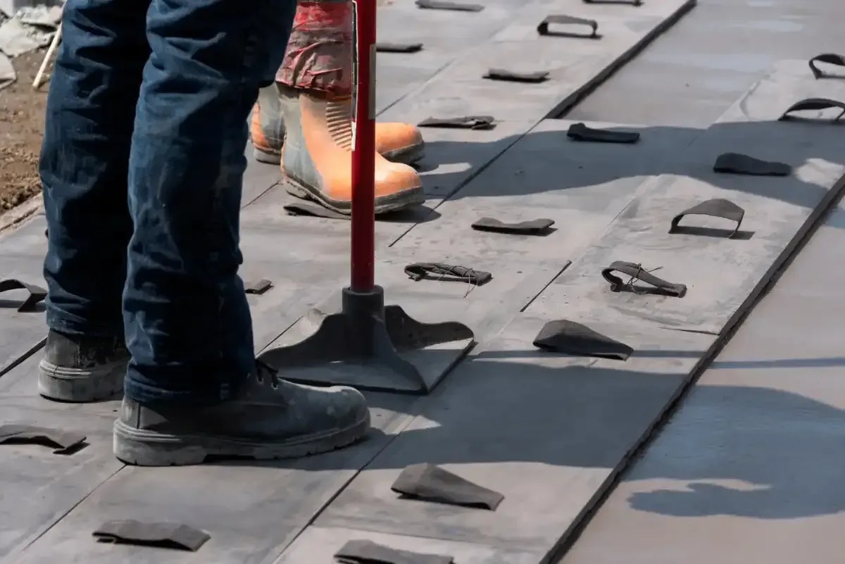 Construction workers imprinting concrete with stamped designs