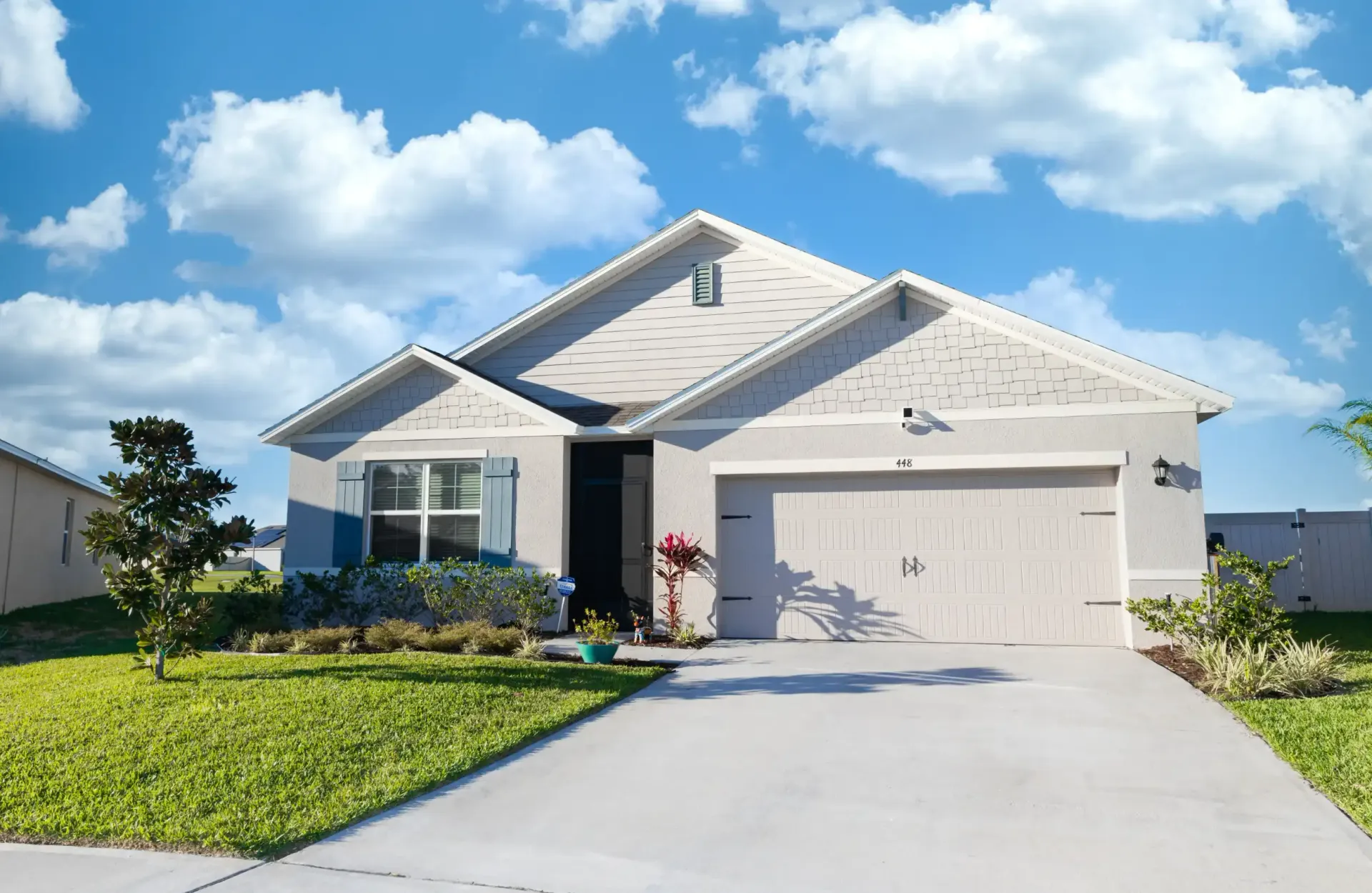 Designer Florida home with plain concrete driveway