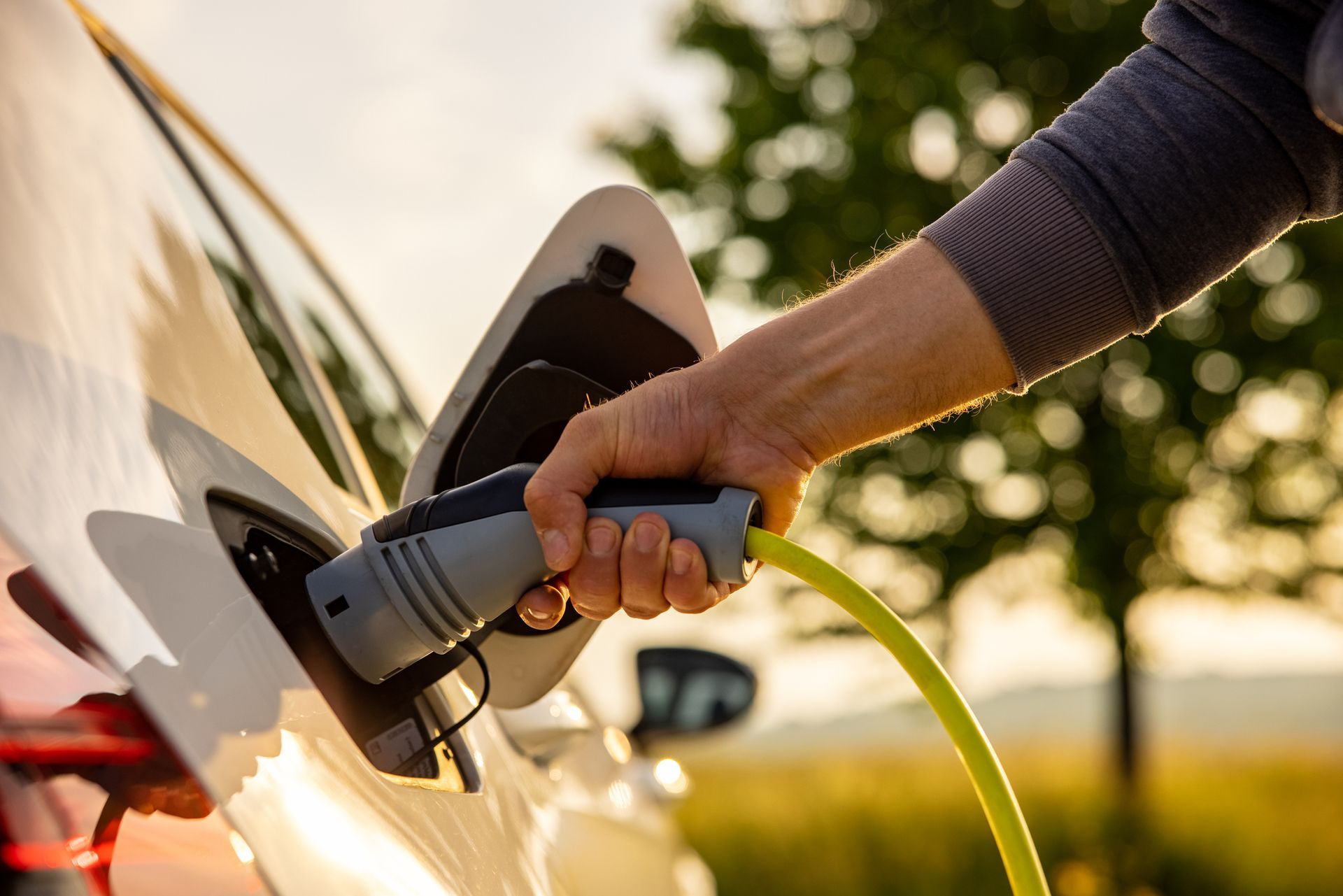 A person is charging an electric car with a charger.