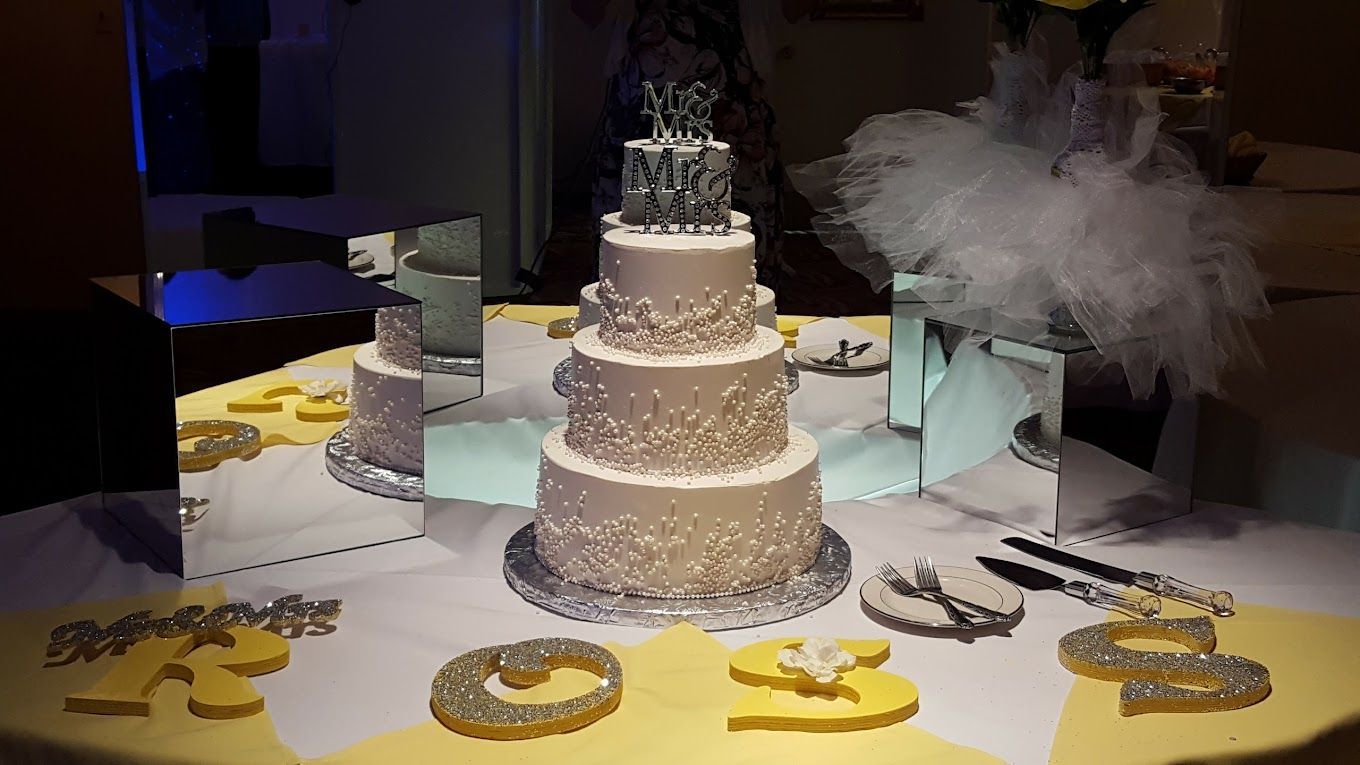 A wedding cake is sitting on a table in front of a mirror