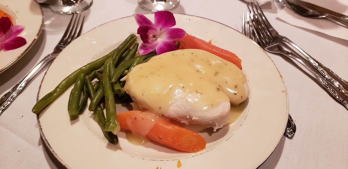 A plate of food with green beans and carrots on a table