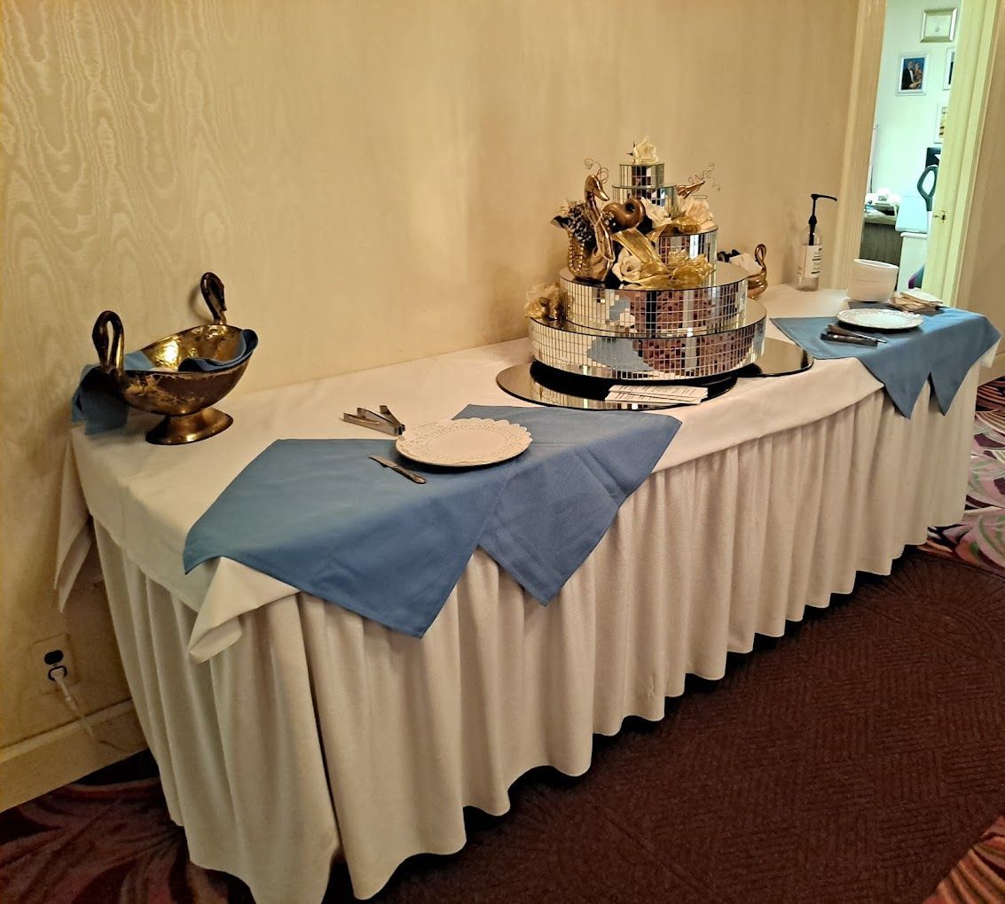 A long table with blue napkins and plates on it