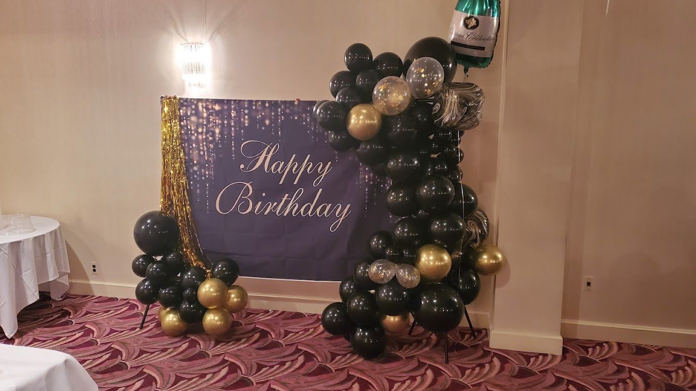 A room filled with balloons and a sign that says `` happy birthday ''