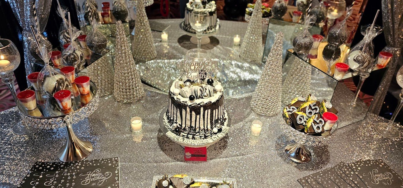 A table topped with a cake , cupcakes , and candles