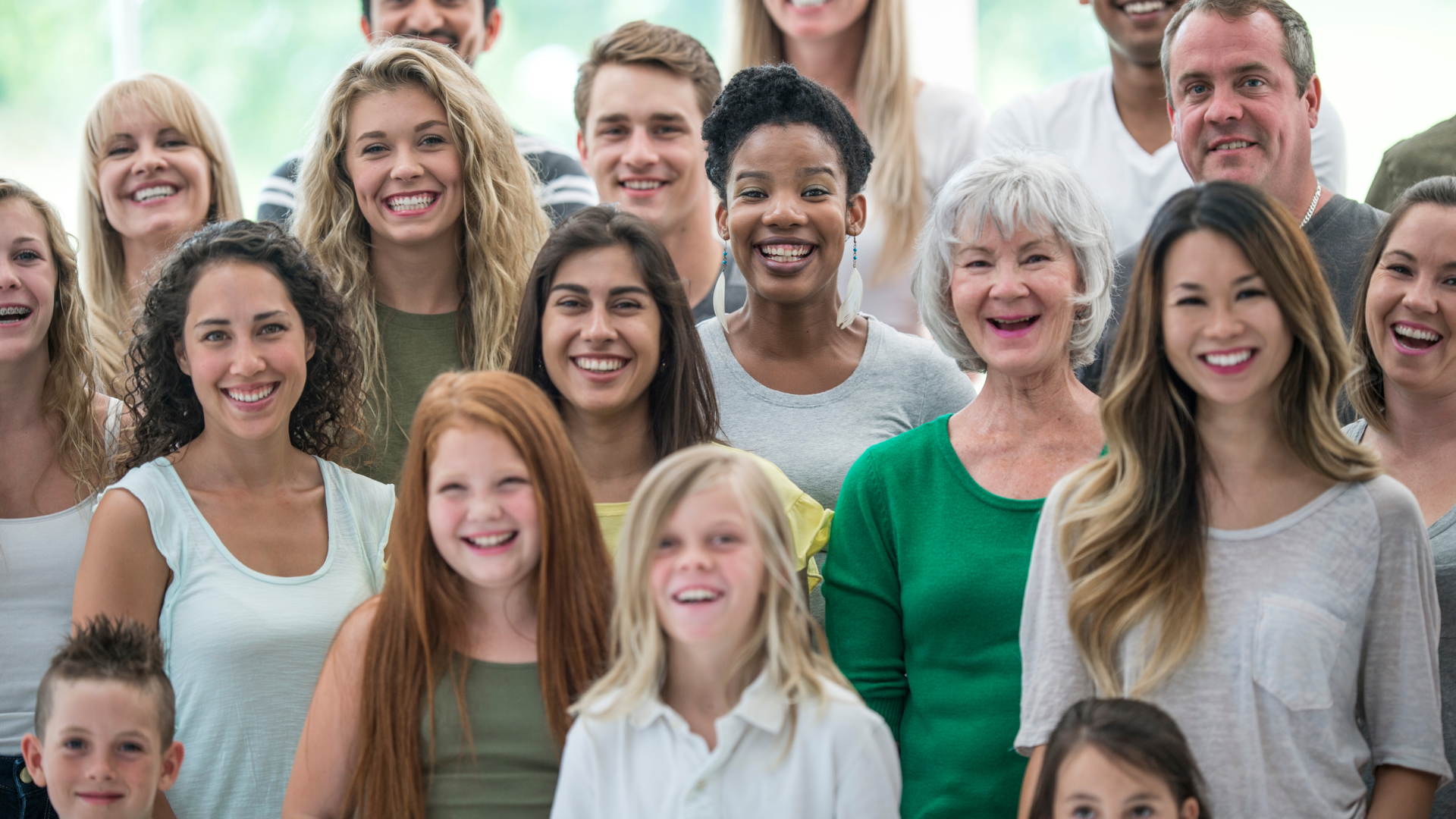 A large group of people are posing for a picture together and smiling
