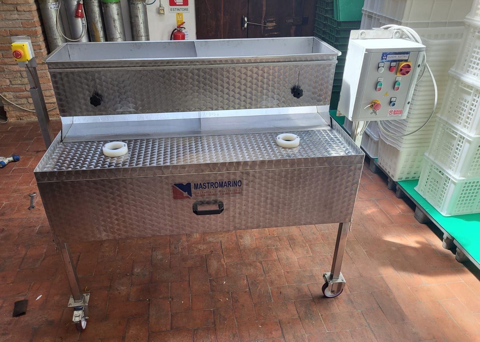 Stazione di lavaggio industriale in acciaio inox con pannello di controllo e contenitori in plastica in configurazione di fabbrica.