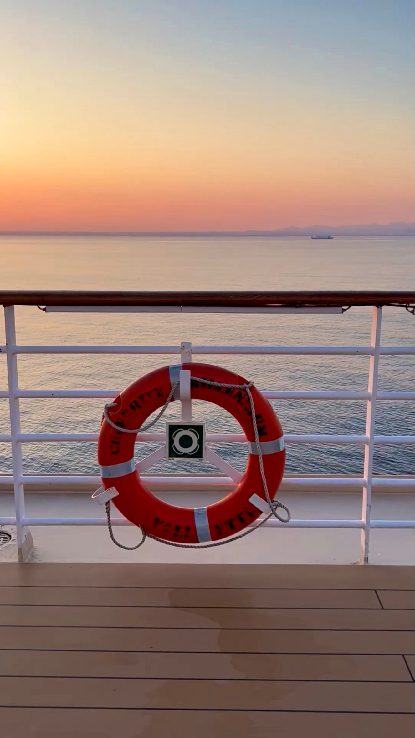 A life preserver is hanging on a railing overlooking the ocean