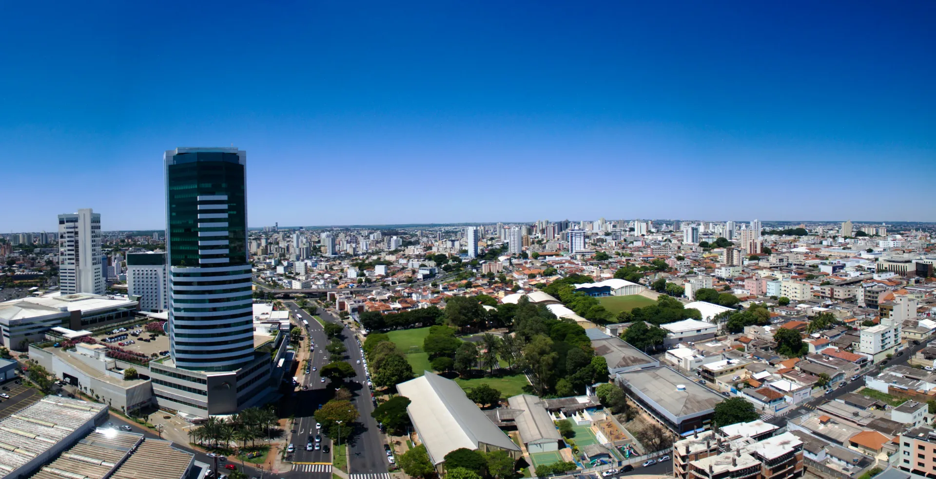Vista aérea de Uberlândia em Minas Gerais com um edifício alto à esquerda.