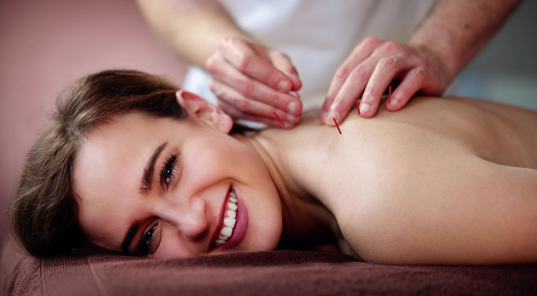 Woman smiling during a back massage on a treatment table