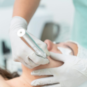 Dental cleaning in progress, with gloved hands using a tool on a patient’s mouth.