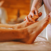 Person receiving a foot massage with lotion in a spa setting