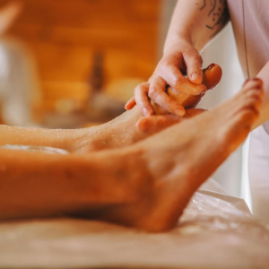 Person receiving a foot massage with lotion in a spa setting