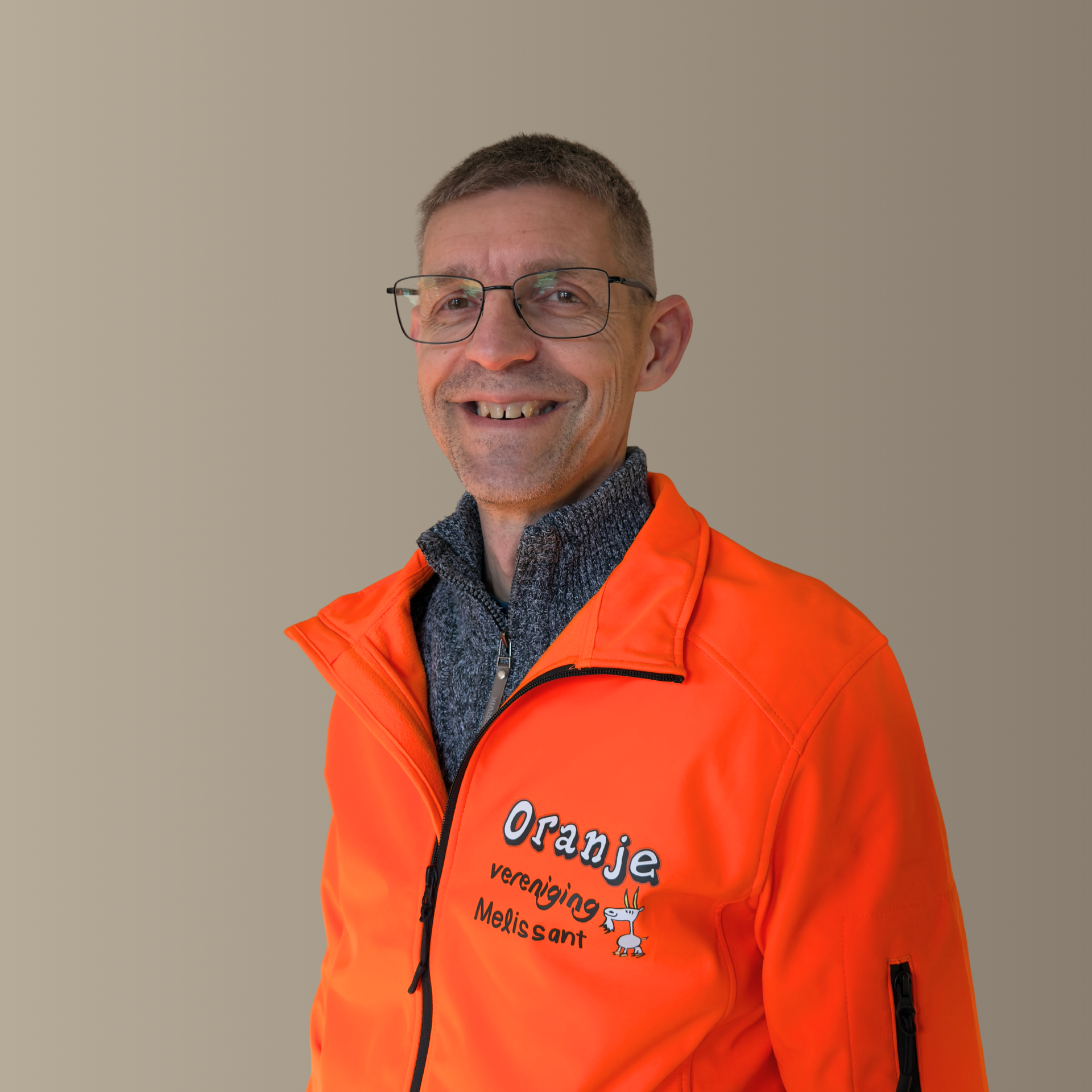Een lachende man draagt ​​een oranje jas met het logo 