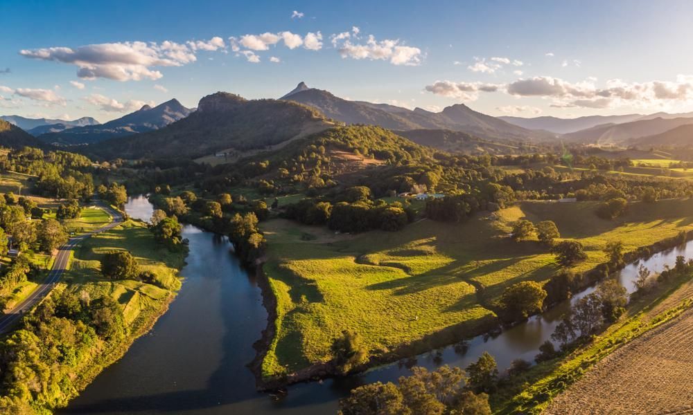 An Aerial View Of A River Surrounded By Mountains And Trees — Custom Air In Towong, NSW