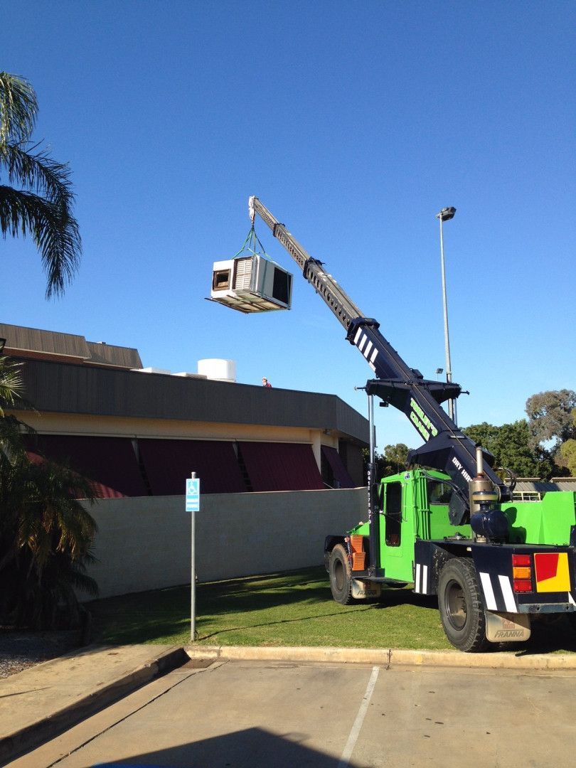 Crane Lifting Air Conditioning Onto Rooftop — Custom Air In East Albury, NSW
