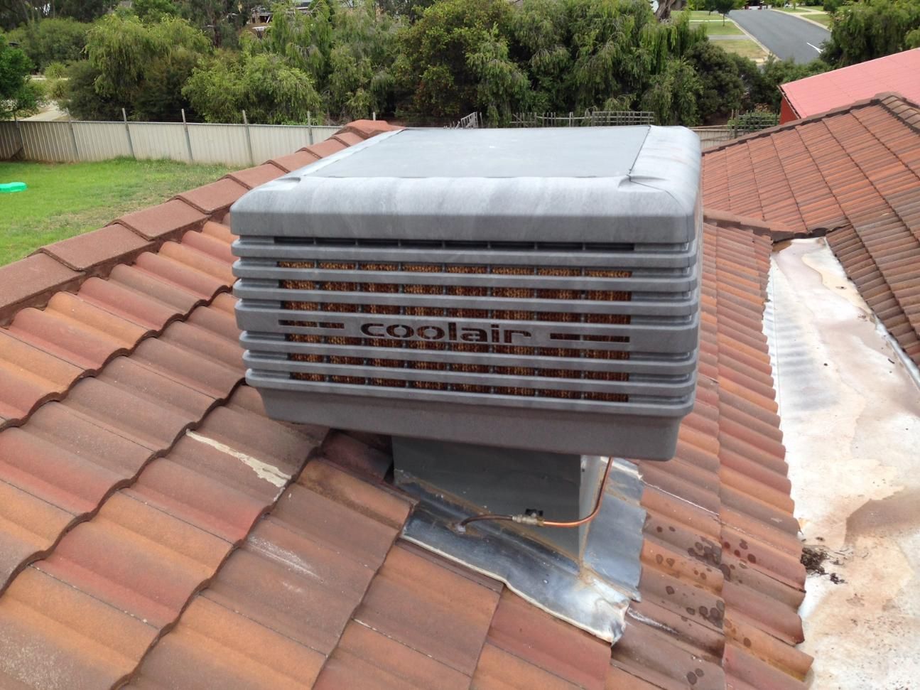 A Coolair Air Conditioner Is On The Roof Of A House — Custom Air In East Albury, NSW