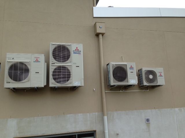 Three Mitsubishi Air Conditioners Are Mounted On The Side Of A Building — Custom Air In East Albury, NSW