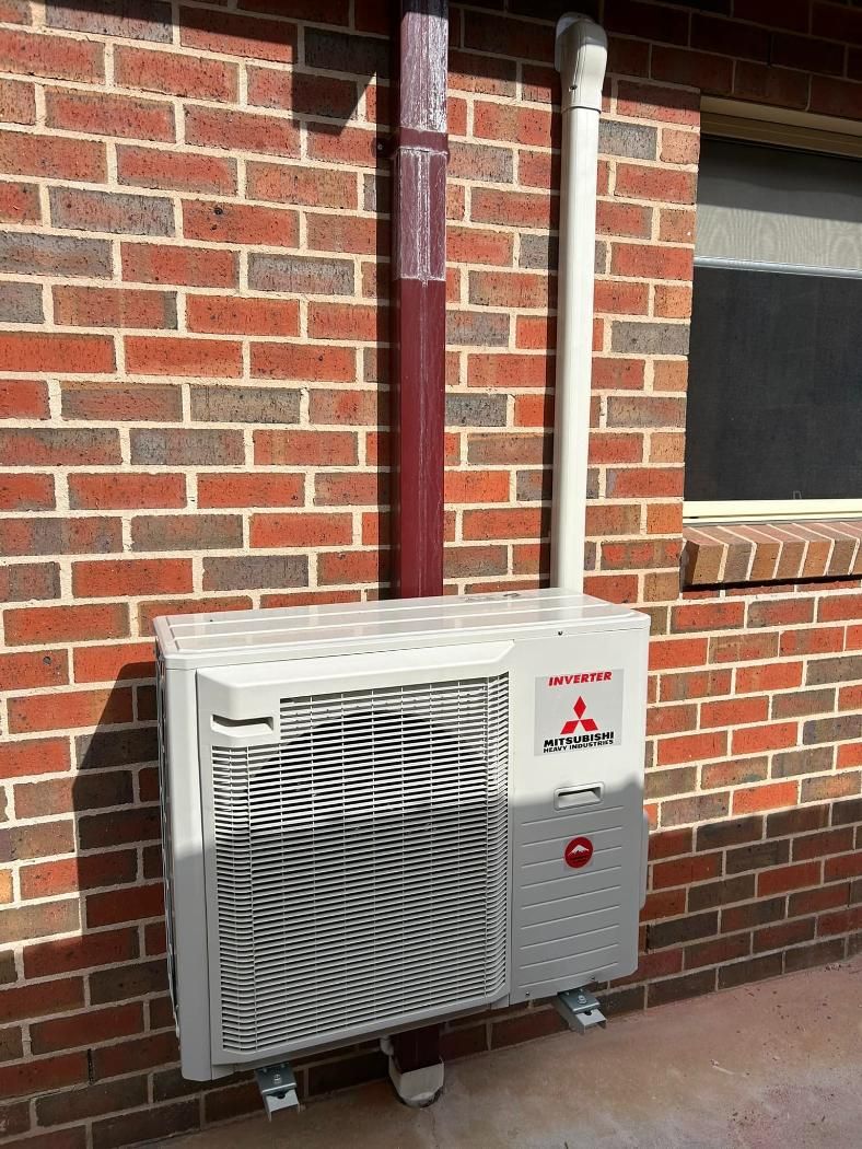 A Mitsubishi Air Conditioner Is Mounted On The Side Of A Brick Building — Custom Air In Towong, NSW