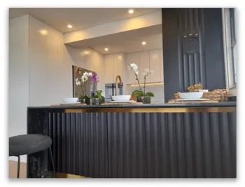 A kitchen with a black counter top and white cabinets A kitchen with a black counter top and white cabinets
