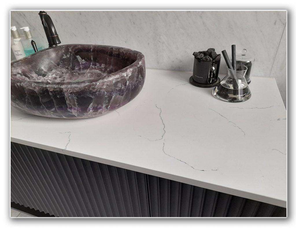 A bathroom sink is sitting on a white counter top. A bathroom sink is sitting on a white counter top.