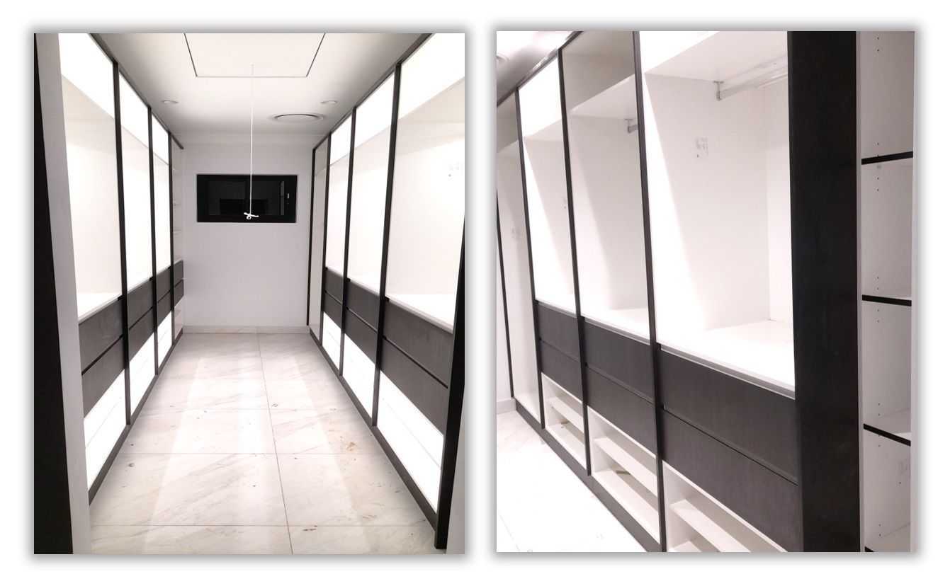A room with a lot of white cabinets on the wall.