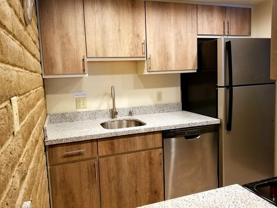 Stylish kitchen design with stainless steel appliances and a refrigerator.