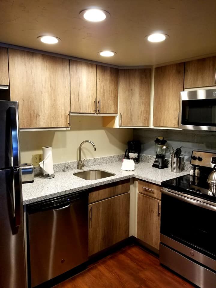 A kitchen with stainless steel appliances and wooden cabinets.