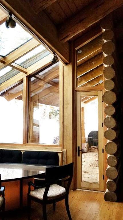 A cozy wooden room featuring a table and chairs, showcasing rustic decor and warm lighting.