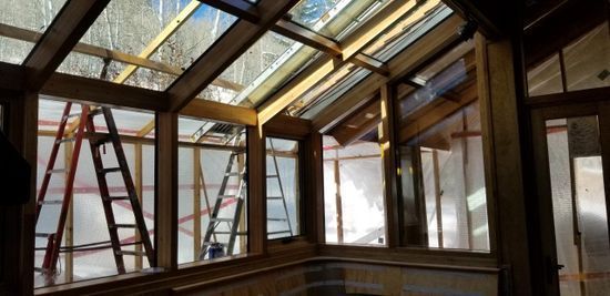 A natural light room with large windows and a ladder, creating a bright and airy atmosphere.