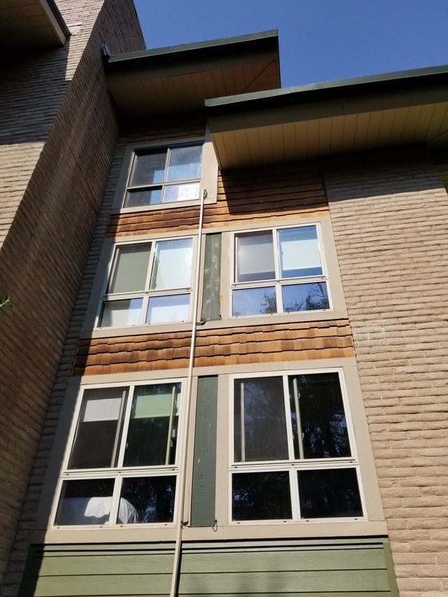 Tall building with numerous windows and a rope hanging from its side.