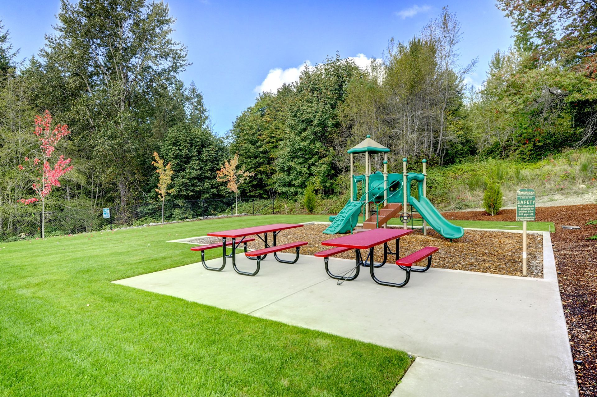 a picnic area with a playground in the background