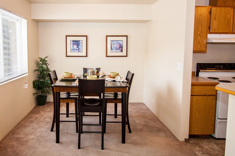 a dining room with a table and chairs and pictures on the wall