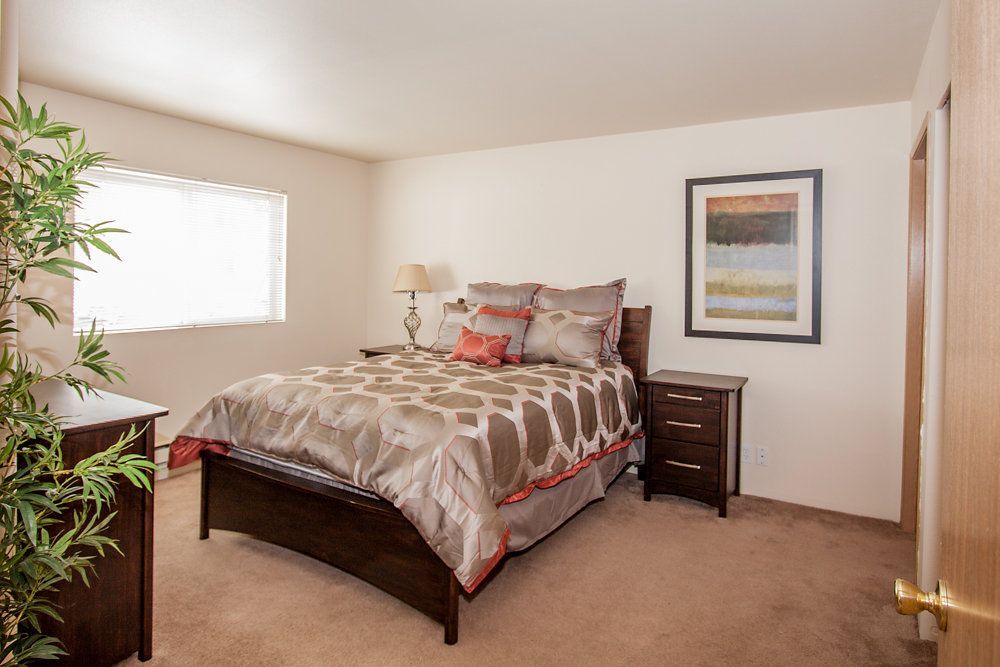 a bedroom with a picture on the wall above the bed