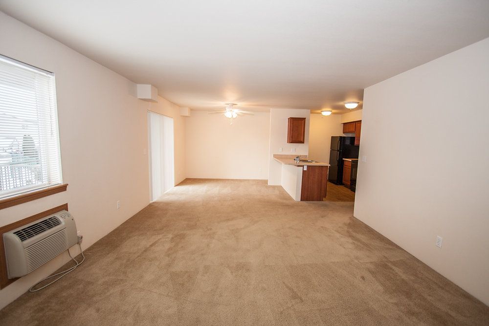 a living room with a ceiling fan and a window