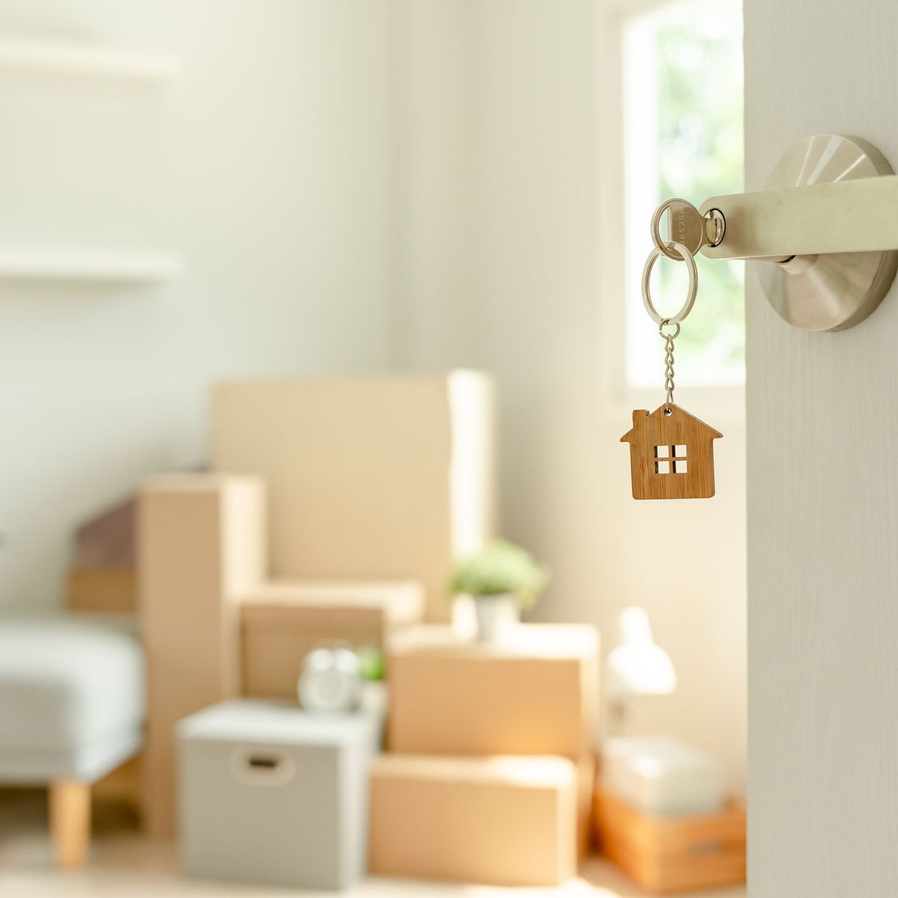 a key with a house on it is hanging from a door handle .