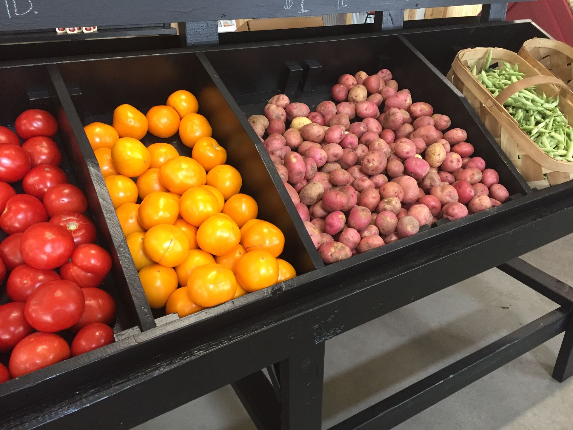 A display of fruits and vegetables including oranges tomatoes and potatoes