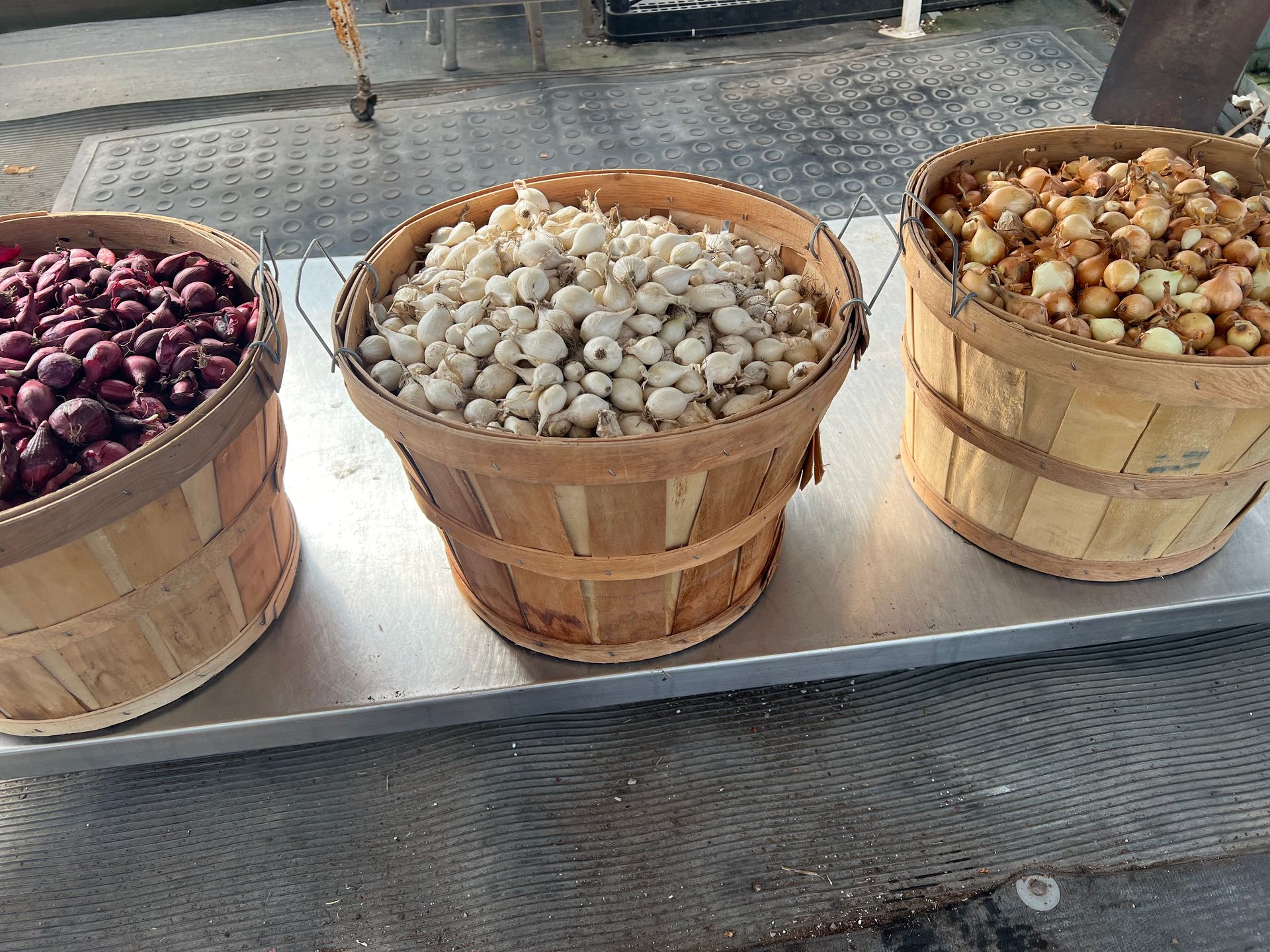 Three baskets filled with different types of food are sitting on a table.
