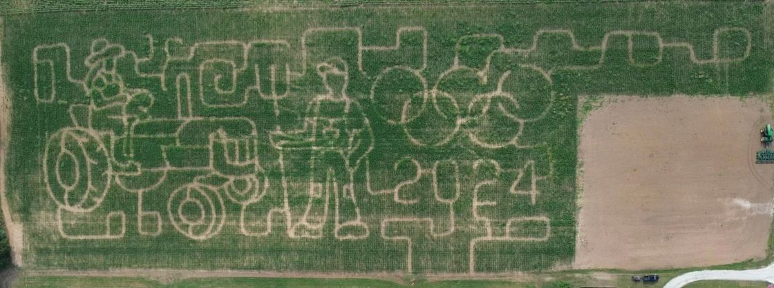 An aerial view of a corn maze in a field