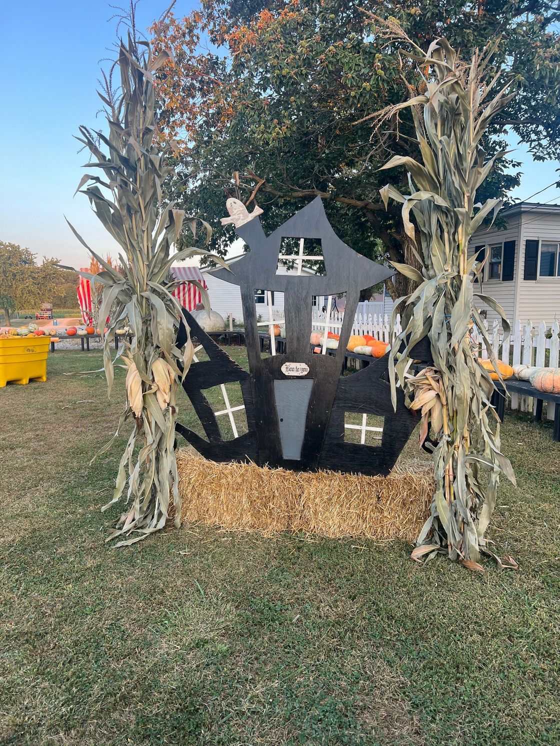 A haunted house is sitting on top of a pile of hay in a field.