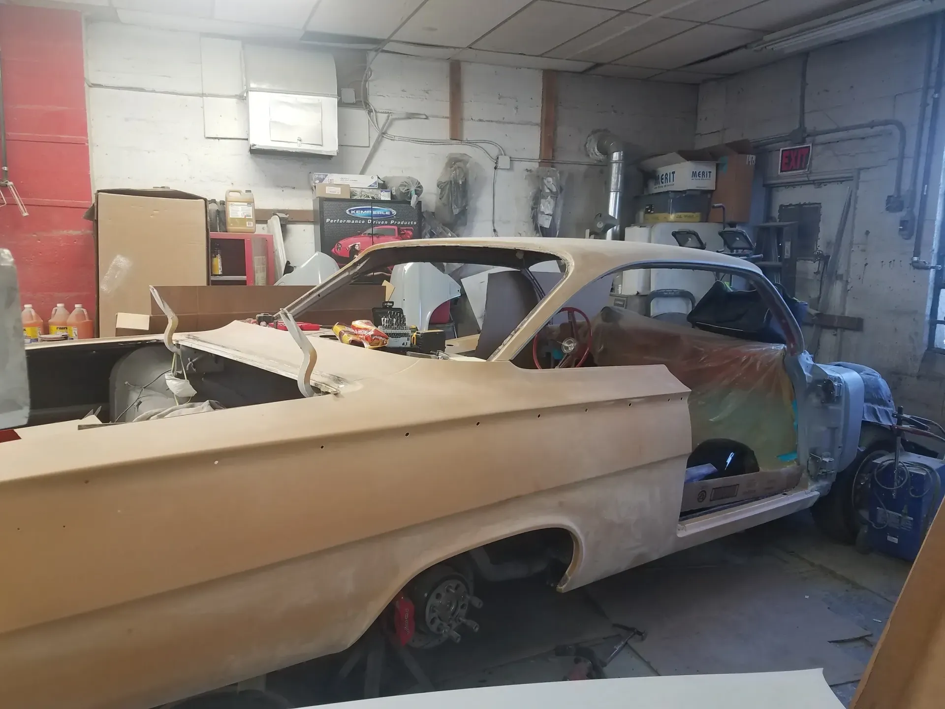 a car is sitting in a garage with the door open .