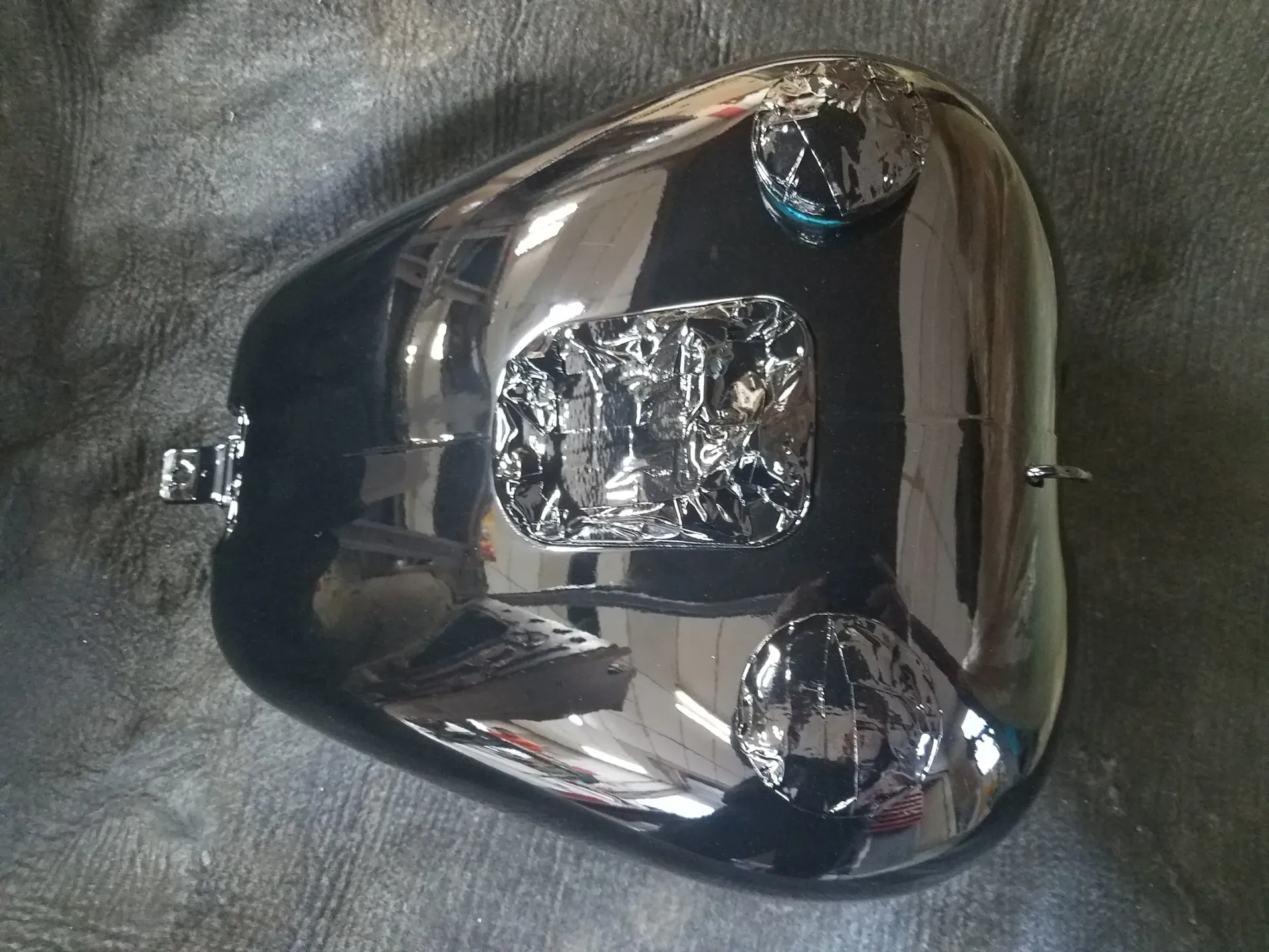 a black motorcycle tank is sitting on a black cloth