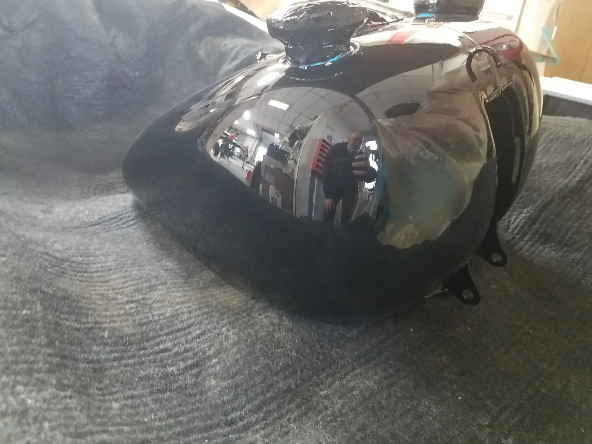 a black motorcycle gas tank is sitting on a table .